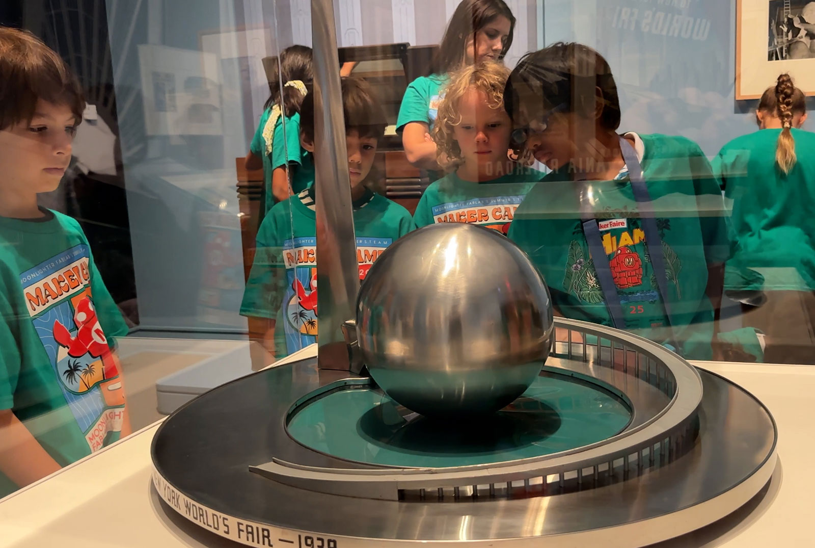 A group of children in a museum gallery looking at an object in a glass case